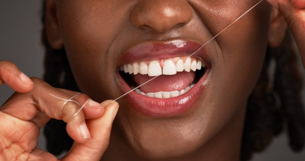A woman is flossing her teeth